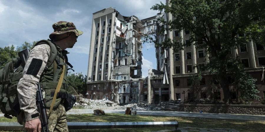 Ein ukrainischer Soldat steht vor dem Gebäude der regionalen Militärverwaltung von Mykolaiv, das bei einem russischen Angriff zerstört wurde. Foto: Evgeniy Maloletka/AP/dpa