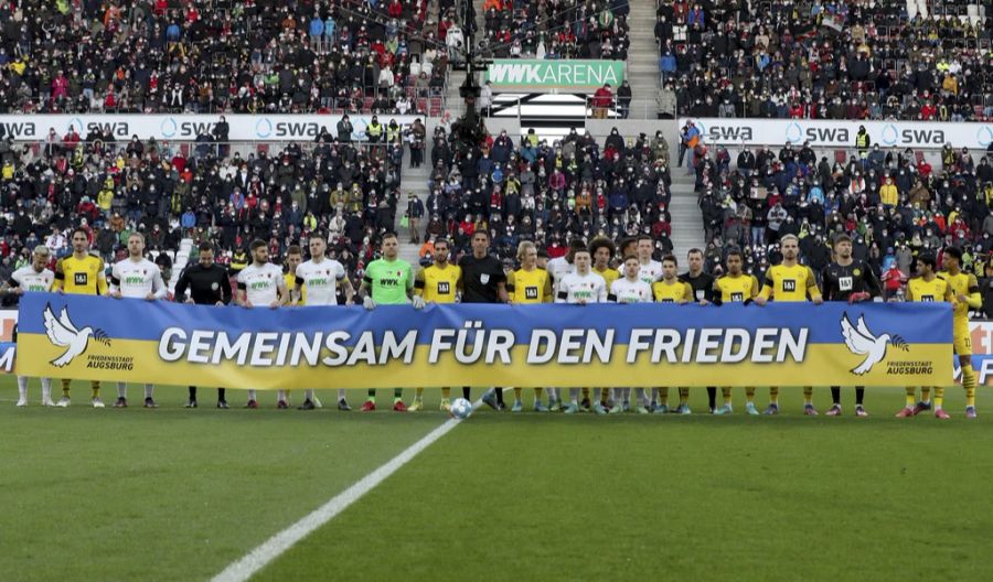 Spieler vom FC Augsburg und vom BVB zeigen sich solidarisch.
