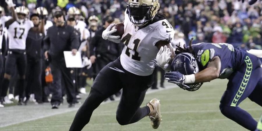 Alvin Kamara (l) von den New Orleans Saints gegen Ryan Neal von den Seattle Seahawks. Foto: John Froschauer/AP/dpa