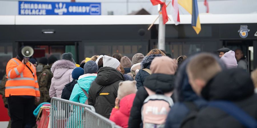 Geflüchtete aus der Ukraine stehen kurz hinter dem Grenzübergang von der Ukraine nach Polen für einen Bus an. Foto: Sebastian Gollnow/dpa