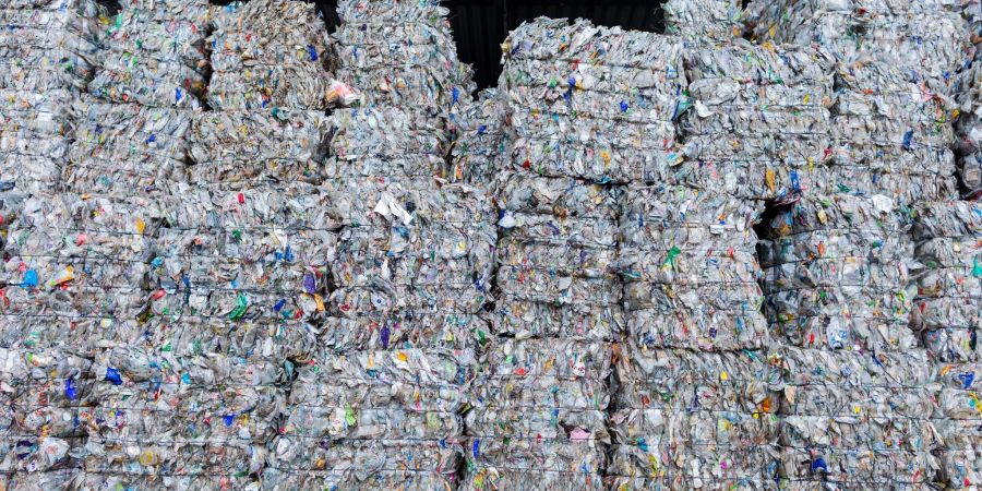 Sortierte Verpackungsabfälle stehen gepresst neben einer Halle, nachdem sie in der Sortieranlage des Entsorgungsunternehmens Remondis getrennt worden sind.