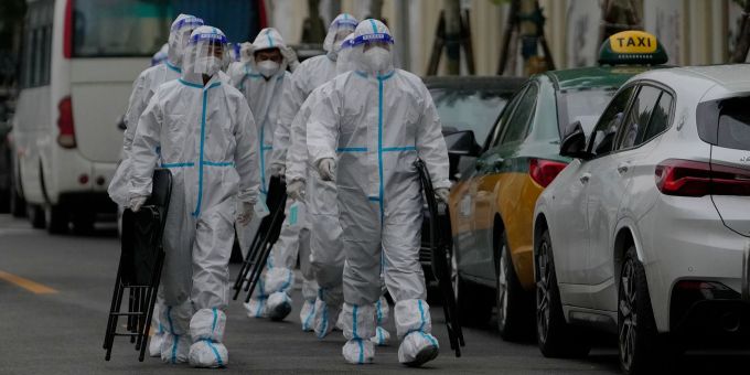 Arbeiter des Gesundheitswesens sind auf dem Weg zu einem abgesperrten Wohnkomplex in Peking. Peking