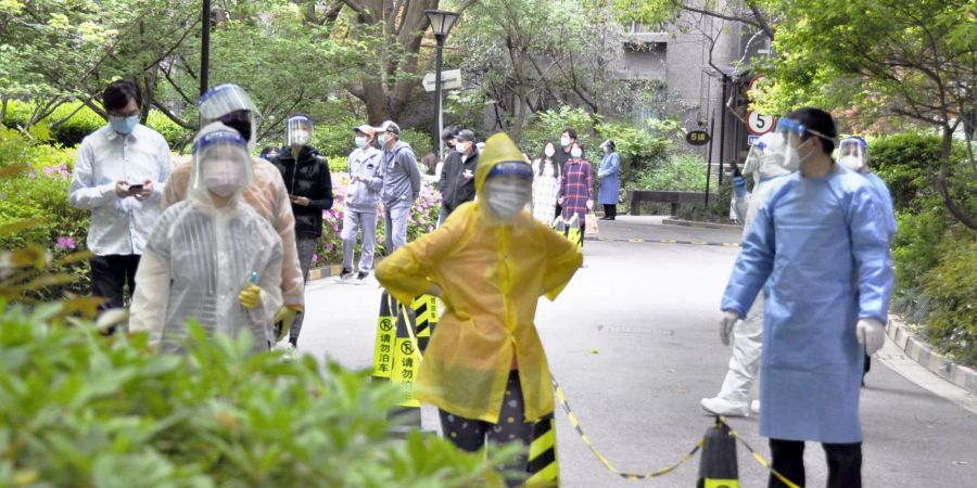 Bewohner einer Wohnanlage in Shanghai warten auf die Durchführung von PCR-Tests.