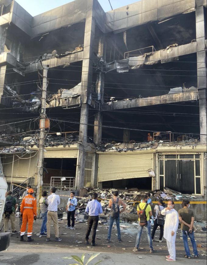 Menschen betrachten das ausgebrannte Haus in Neu Delhi, Indien. Neu Delhi Indien