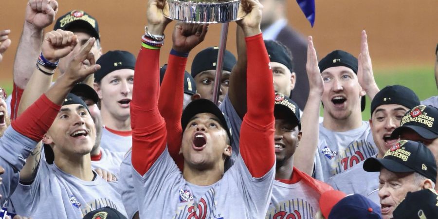 Baseball-Star Juan Soto (M, mit Pokal) feiert mit den Washington Nationals die MLB-Meisterschaft.