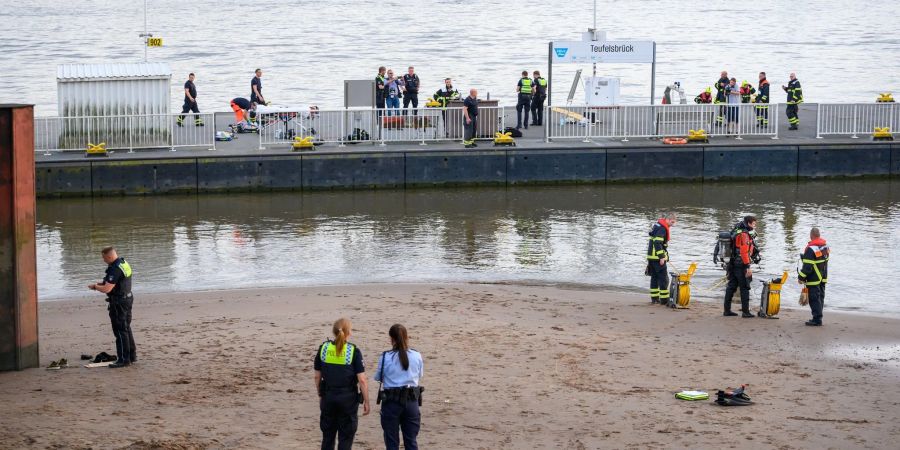 Einsatzkräfte von Feuerwehr, DLRG und Polizei während der Suche auf dem Anleger "Teufelsbrück" und am Ufer der Elbe.
