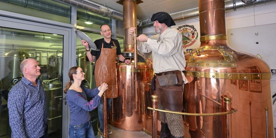 Am Sudkessel der Rathausbrauerei im alten Rathaus nehmen Holger Roger Pelz (l-r) von den Fürstenwalder Brau-Freunden und Katrin Riegel vom Tourismusverband zusammen mit Oliver Wittkopf und Bernd Norkeweit an einem Braukurs teil.