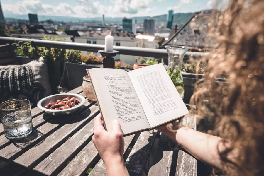 Buch lesen auf dem Balkon