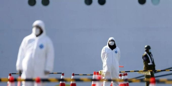 Sicherheitskräfte stehen vor der «Diamond Princess». Das Schiff hatte wegen des neuartigen Coronavirus Sars-CoV-2 zwei Wochen lang im japanischen Yokohama unter Quarantäne gestanden. Foto: Eugene Hoshiko/AP/dpa Sicherheitskräfte stehen vor der «Diamond Princess». Das Schiff hatte wegen des neuartigen Coronavirus Sars-CoV-2 zwei Wochen lang im japanischen Yokohama unter Quarantäne gestanden. Foto: Eugene Hoshiko/AP/dpa