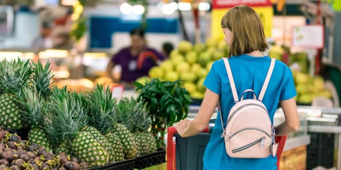 Der Gang an die Kasse ist bei jedem Einkauf unvermeidlich. Frau im Supermarkt.