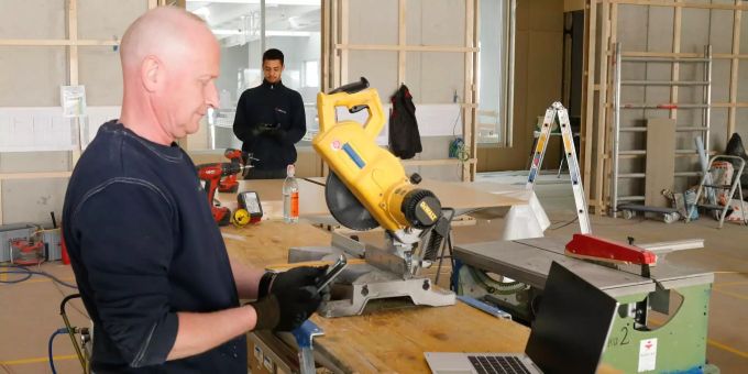 Zwei Mitarbeitende der Röösli AG erhalten auf der Baustelle – in gebührendem Abstand zueinander – aktuelle Informationen per Smartphone. Röösli AG