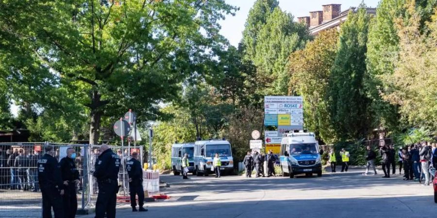 Polizisten stehen am Eingang zum Neuen-Zwölf-Apostel-Friedhof in Schöneberg. Die Beerdigung einer Mutter aus einem bekannten arabischstämmigen Clan in Berlin wird von der Polizei mit 200 Beamten begleitet. Foto: Paul Zinken/dpa