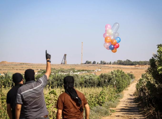 Maskierte Palästinenser lassen in der Nähe eines Flüchtlingslagers entlang der Grenze zwischen Israel und dem Gazastreifen Ballons mit Brandsätzen in Richtung Israel aufsteigen. Nahost-Konflikt