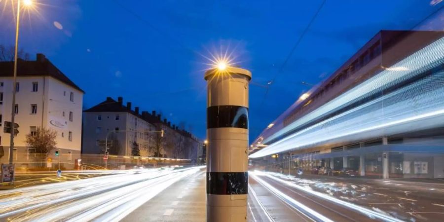 Eine Blitzsäule mit kombinierter Überwachung von Rotlicht und Geschwindigkeit an einer Ampelkreuzung. Foto: Daniel Karmann/dpa