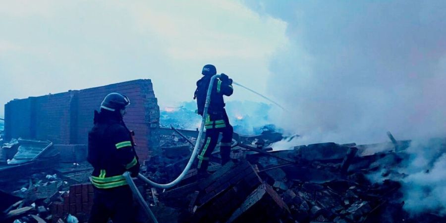 HANDOUT - Auf diesem vom ukrainischen Katastrophenschutz zur Verfügung gestellten Foto löschen Rettungskräfte ein Feuer in einem Wohnhaus, das nach einem Angriff zerstört wurde. Fot...