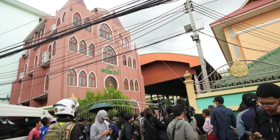 Vor einer Schule in der thailändischen Provinz Nonthaburi versammelt sich eine Menschenmenge, nachdem hier Schüsse gefallen waren. Foto: Sakchai Lalit/AP/dpa