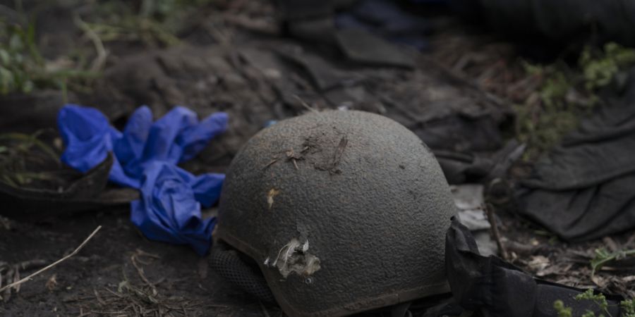 ARCHIV - Ein beschädigter Helm liegt auf dem Boden an einer Stelle, an der die Leichen von vier ukrainischen Soldaten in einem Gebiet nahe der Grenze zu Russland in der Region Charkiw ...
