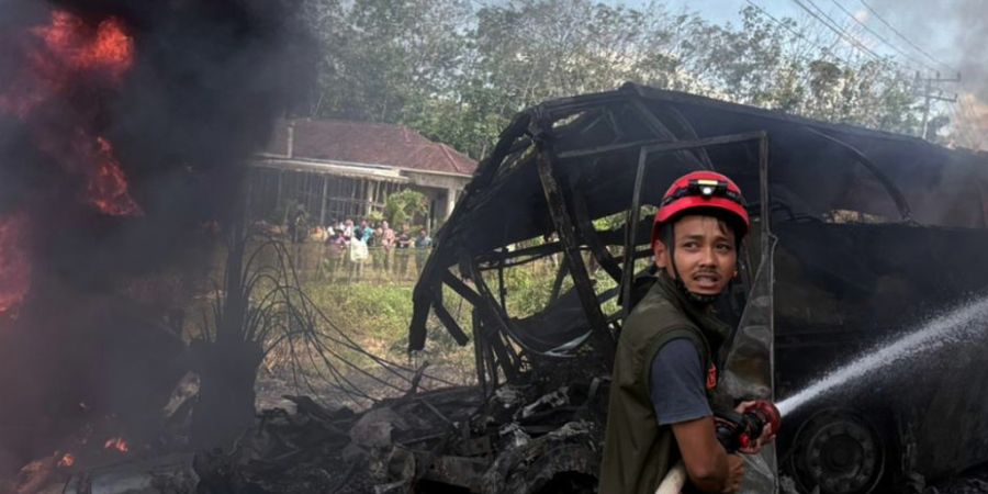 dpatopbilder - HANDOUT - Ein Retter versucht das Feuer zu löschen, nachdem ein Passagierbus mit einem Tankwagen in der Provinz Süd-Sumatra zusammengestoßen ist. Foto: Uncredited/Sout...