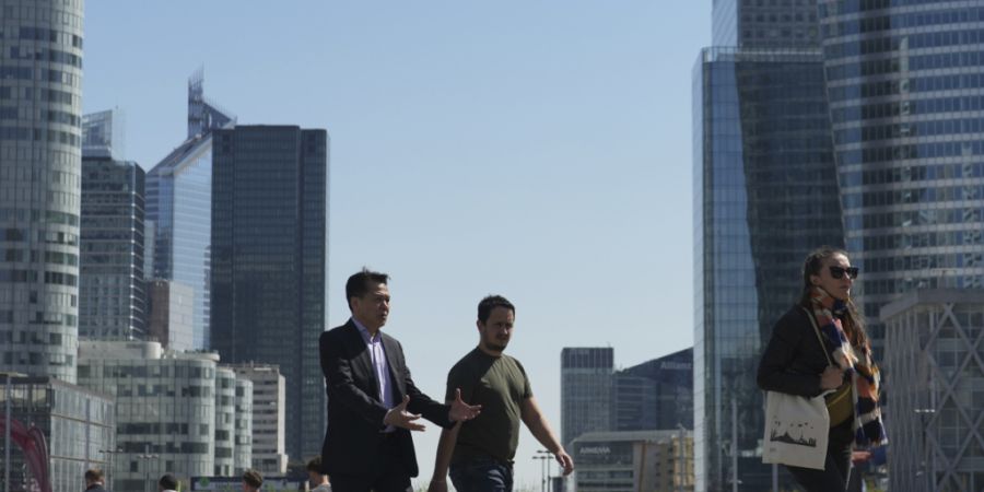 ARCHIV - Menschen schlendern durch das Geschäftsviertel La Defense außerhalb von Paris. Das hoch verschuldete Frankreich erhält nach monatelangem Ringen endlich einen Haushalt für d...