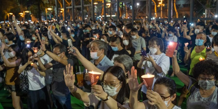 ARCHIV - Demonstranten versammeln sich im Victoria Park zu einer Mahnwache zum Gedenken an die Opfer des Tiananmen-Massakers. Die Menschen halten fünf Finger zum Zeichen von 5 Forderun...