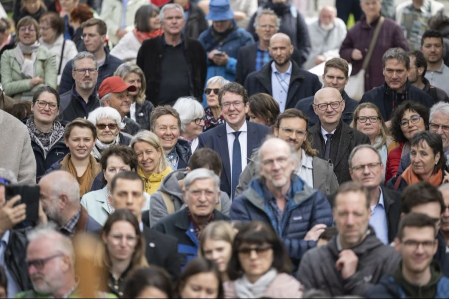 Suchbild mit Bundesrat: Albert Rösti inmitten der Bevölkerung nach der wöchentlichen Sitzung mit dem Bundesrat ausserhalb des Bundeshauses, am 26. April in Winterthur. Rechts hinter ihm folgt wie ein Schatten ein Personenschützer.