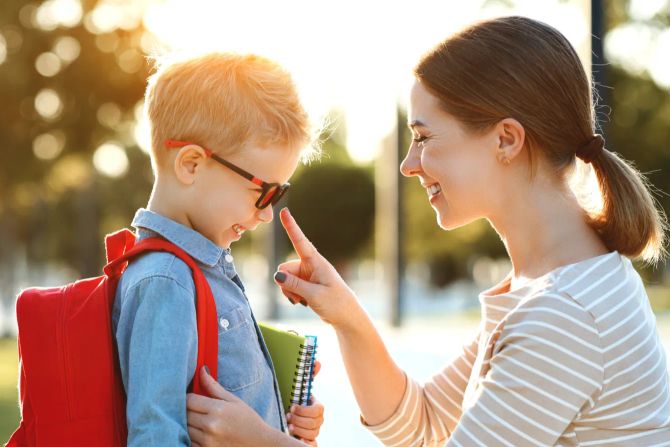 Mutter, Sohn, Schulkind mit Tasche und Heften