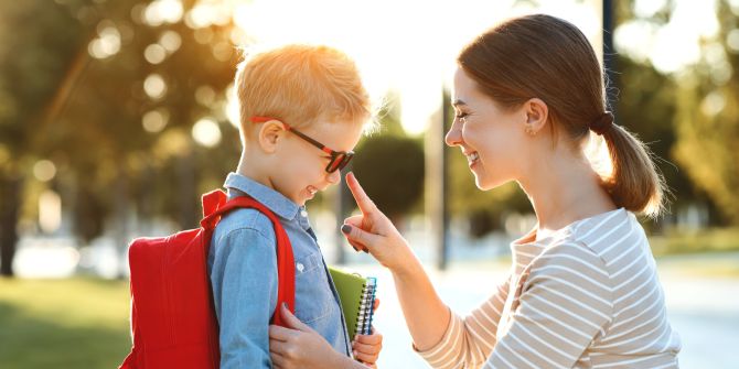 Mutter, Sohn, Schulkind mit Tasche und Heften