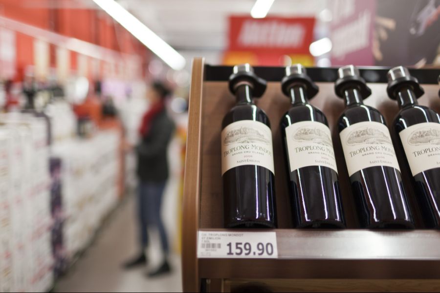 Alkoholflaschen werden entweder mit Pappkarten ersetzt oder mit Diebstahlsicherungen versehen, wie hier in einem Denner.