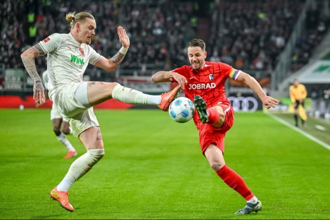 Augsburgs Marius Wolf (l) in der Bundesliga Aktion gegen Freiburgs Christian Günter (r). Bundesliga