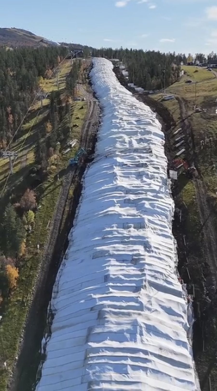 Die unter Planen verdeckten Schneemassen sorgen im finnischen Skigebiet für ein kurioses Bild.