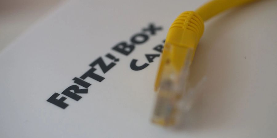 Ein Netzwerkkabel liegt auf einem Fritz!-Box-Router der Firma AVM.