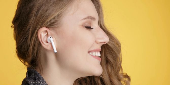 Lachende Frau mit AirPods im Ohr