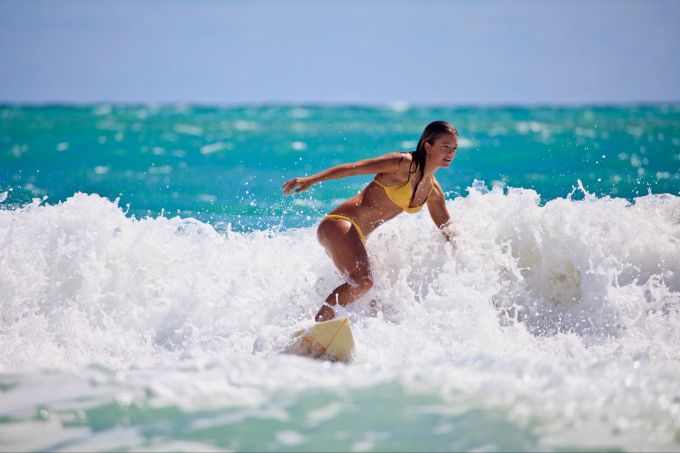Fliegen Sie weg und lernen Sie was Neues – Surfen ist gut für die Seele und macht Spass. Frau surft