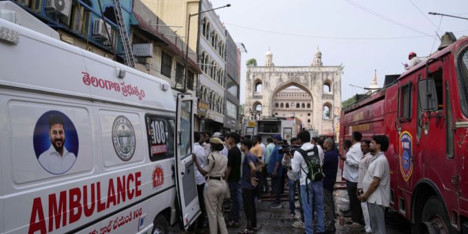 Ein Krankenwagen und ein Löschfahrzeug warten vor einem Gebäude, das in der Nähe des Charminar-Viertels in Hyderabad, was in Brand geraten ist. Löschfahrzeug