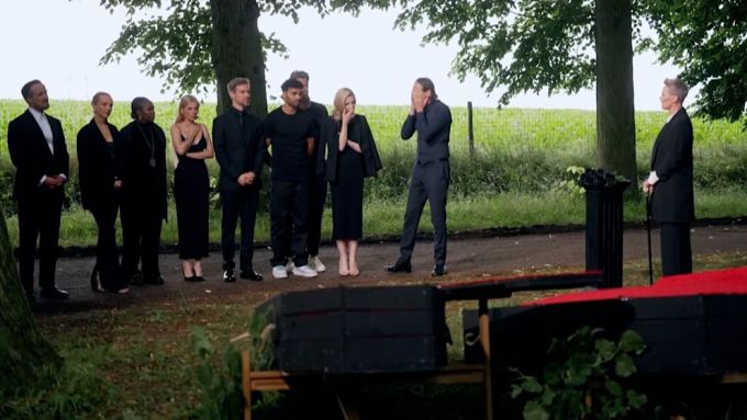 Die anderen Kandidaten reagieren geschockt, als Voss-Tecklenburg beerdigt wird. Die Grabrede hält Show-Gastgeberin Sonja Zietlow (56, ganz rechts). Martina Voss-Tecklenburg