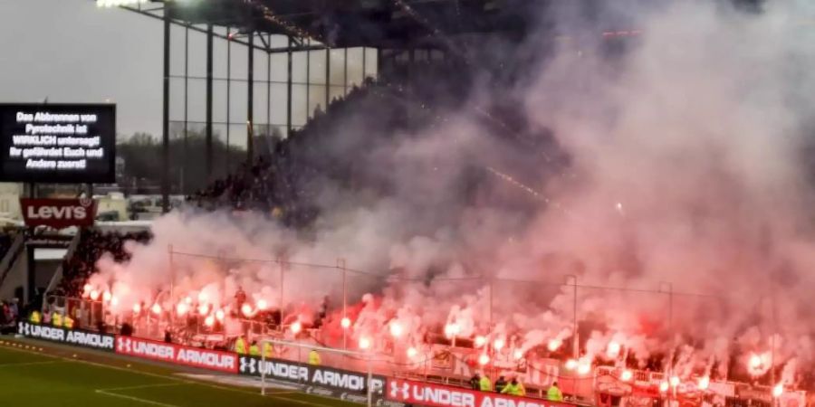 Fans des FC St. Pauli brennen während des Spiels gegen den Hamburger SV Pyrotechnik ab. Foto: Axel Heimken/dpa