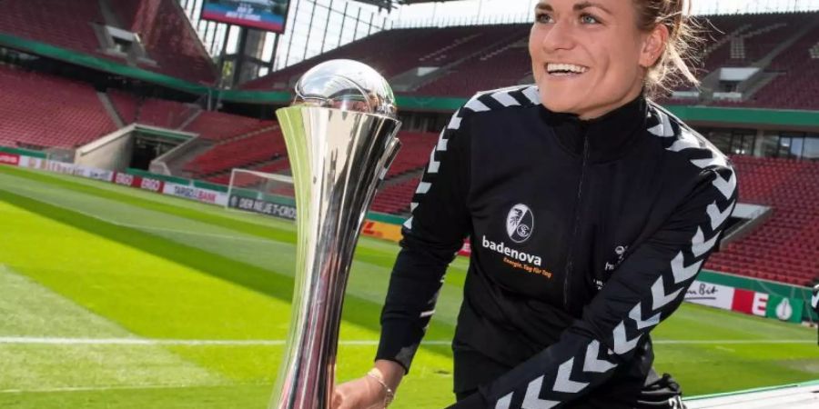 Freiburgs Clara Schöne mit der DFB-Pokal-Trophäe. Foto: Marius Becker