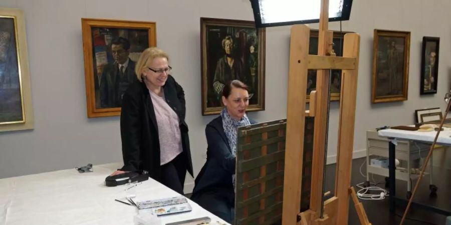 Inge Herold (l), stellvertretende Direktorin der Kunsthalle Mannheim, betrachtet die Arbeit der Restauratorin der Kunsthalle, Katrin Radermacher. Foto: Kunsthalle Mannheim