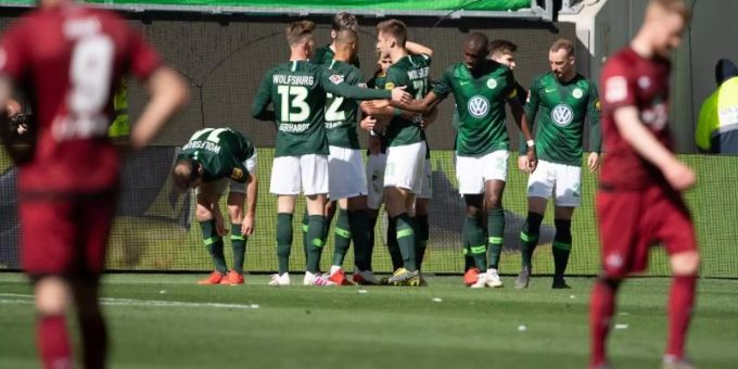 Wolfsburgs Spieler jubeln nach dem 1:0, die Nürnberger lassen im Vordergrund die Köpfe hängen. Foto: Swen Pförtner Wolfsburgs Spieler jubeln nach dem 1:0, die Nürnberger lassen im Vordergrund die Köpfe hängen. Foto: Swen Pförtner