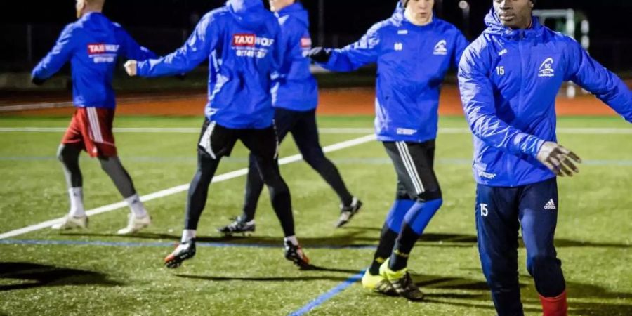 Kebba Manneh (r) beim Training mit seinen Teamkollegen vom SC Lauchringen. Foto: Christoph Schmidt/dpa