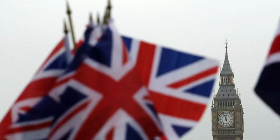 ARCHIV - Britische Flaggen wehen in der Nähe des berühmten Uhrturms Big Ben. Die Unterhändler beraten immer noch über den Brexit-Handelspakt. Foto: Matt Dunham/AP/dpa