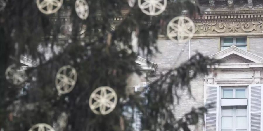 Hinter einem Weihnachtsbaum ist das Fenster des päpstlichen Ateliers geschlossen. Foto: Gregorio Borgia/AP/dpa