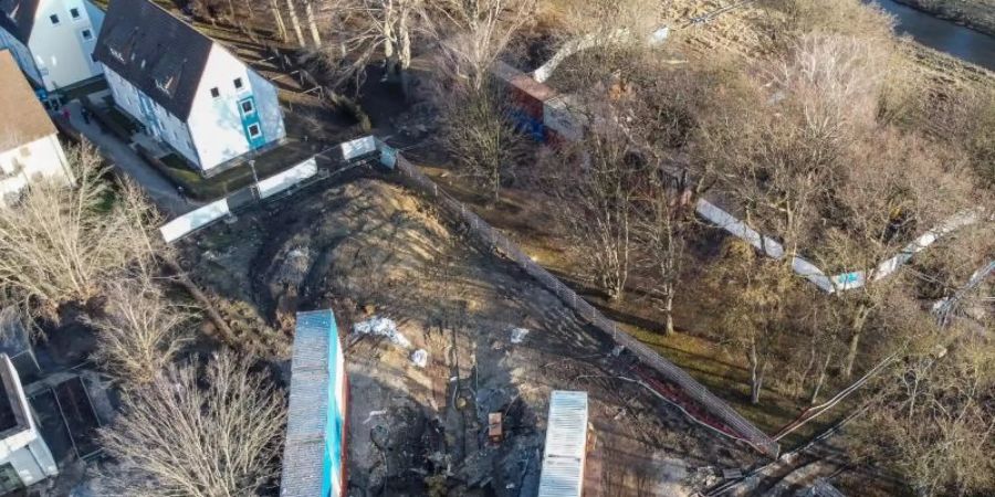 Blick auf einen Krater nach der kontrollierten Sprengung einer 10-Zentner-Bombe aus dem Zweiten Weltkrieg, der von Containern umrandet ist. Foto: Swen Pförtner/dpa