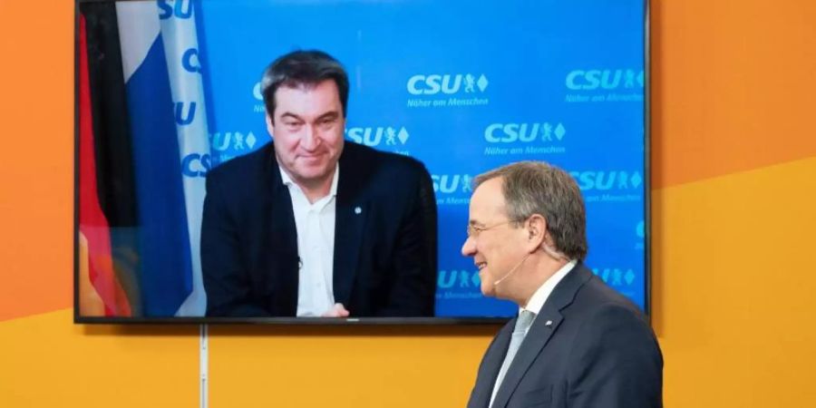 Armin Laschet, Ministerpräsident von Nordrhein-Westfalen und Landesvorsitzender der CDU in Nordrhein-Westfalen, steht in einem Studio in Köln, während CSU-Chef Markus Söder zugeschaltet ist. Foto: Federico Gambarini/dpa-POOL/dpa