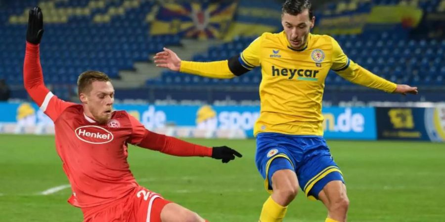 Braunschweigs Dominik Wydra (r) und Rouwen Hennings von Fortuna Düsseldorf kämpfen um den Ball. Foto: Swen Pförtner/dpa