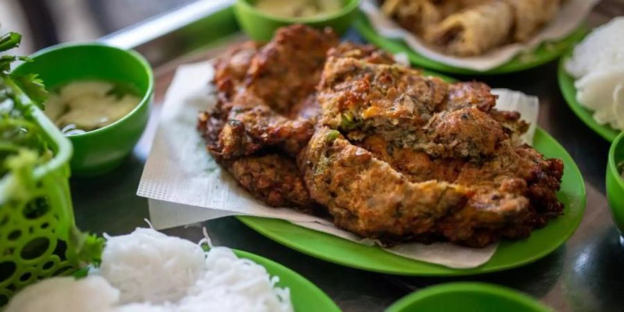 Das Wurm-Omelett wird meist mit Reisnudeln, einer süsssauren Fischsauce und einem Glas Eistee serviert. Foto: Chris Humphrey/dpa