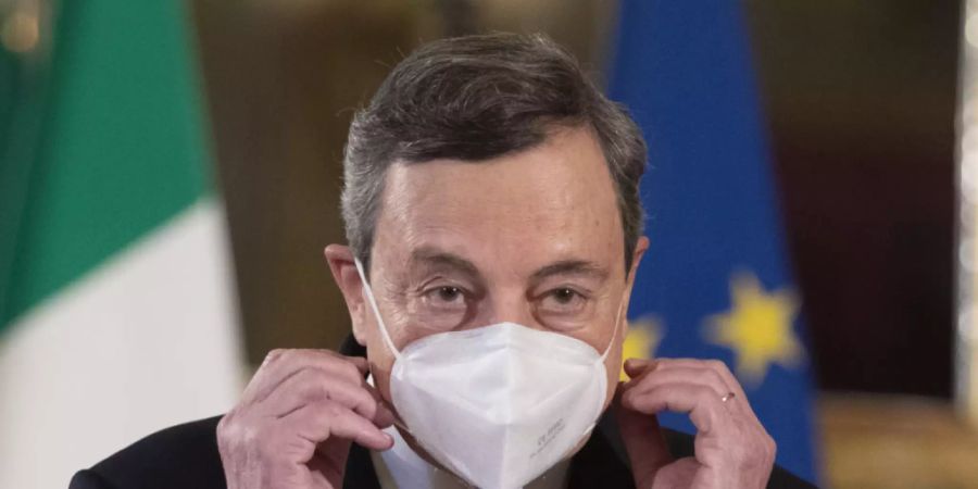 ARCHIV - Mario Draghi, früherer Präsident der Europäischen Zentralbank (EZB), zieht im Quirinale-Palast an seinem Mund-Nasen-Schutz. Foto: Alessandra Tarantino/AP/dpa