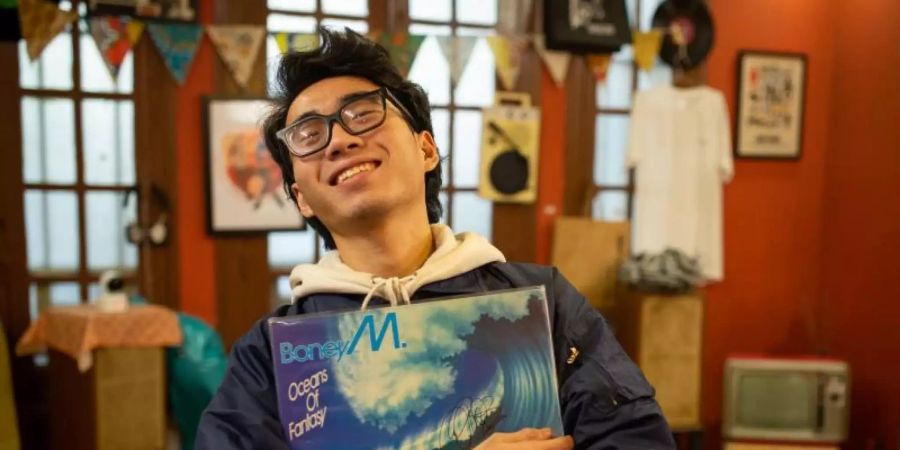 Hung, Mitarbeiter des LP Club, hält die Schallplatte «Oceans of Fantasy» von Boney M. Wenn in Vietnam geheiratet wird, darf Boney M so gut wie nie fehlen. Foto: Chris Humphrey/dpa