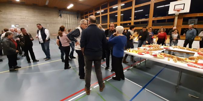 Mehrere Personen in einer Mehrzweckhalle.