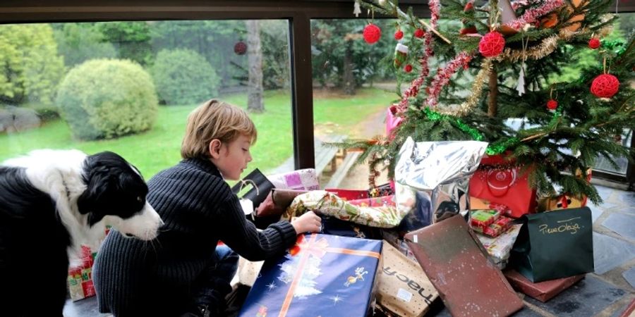 Junge begutachtet Weihnachtsgeschenke